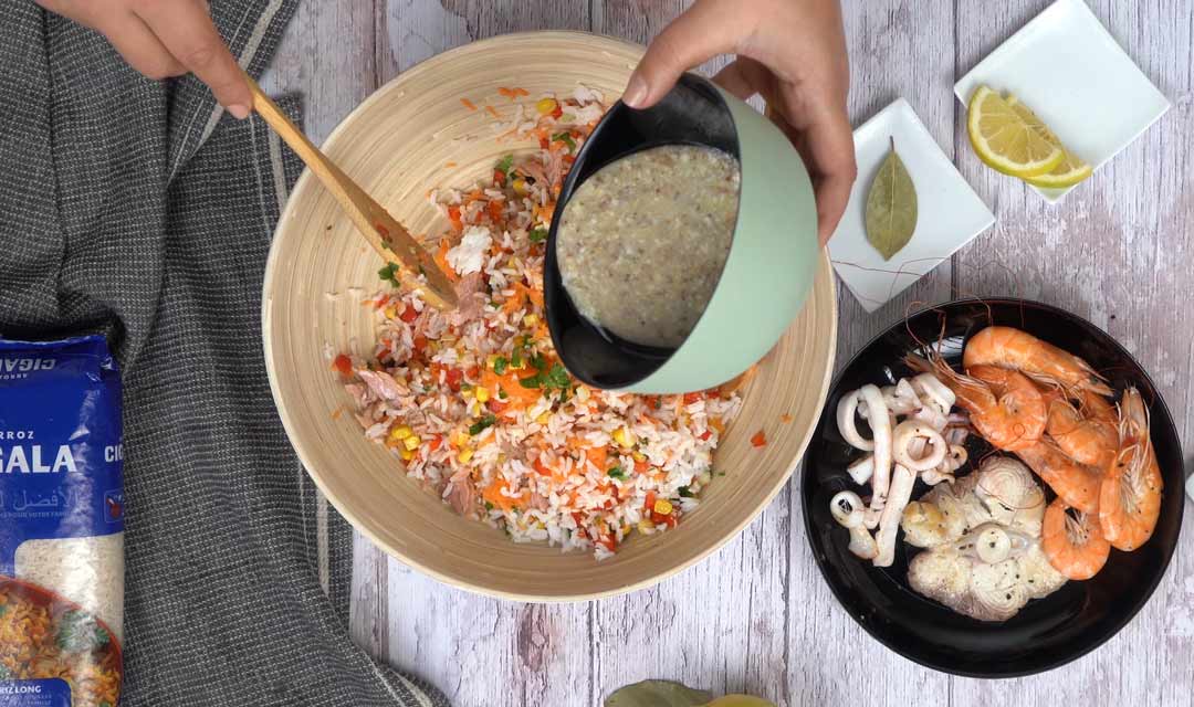 دمج المكونات و تتبيل الصلصة لإعداد سلطة الأرز بالفواكه البحرية