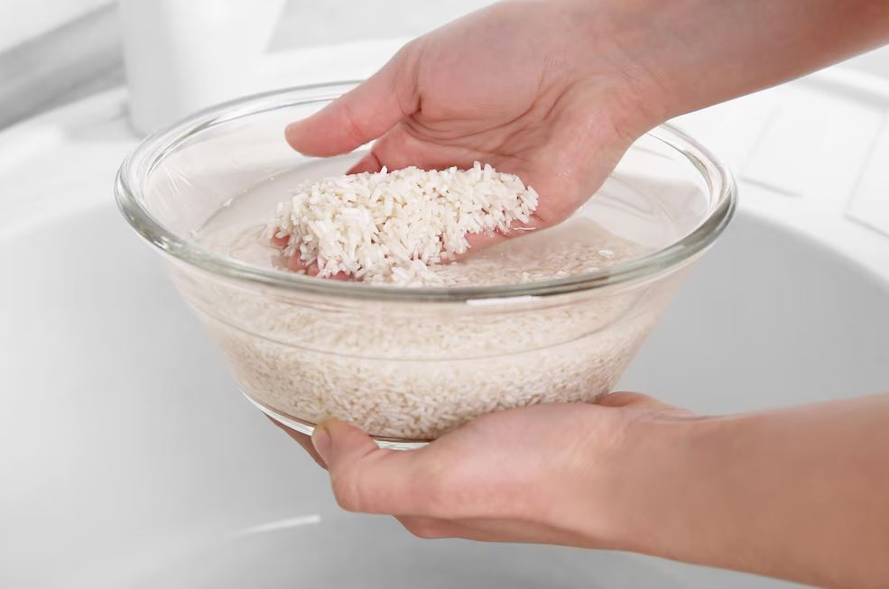 Des mains rince du riz dans un bol d'eau. Sources and related content 