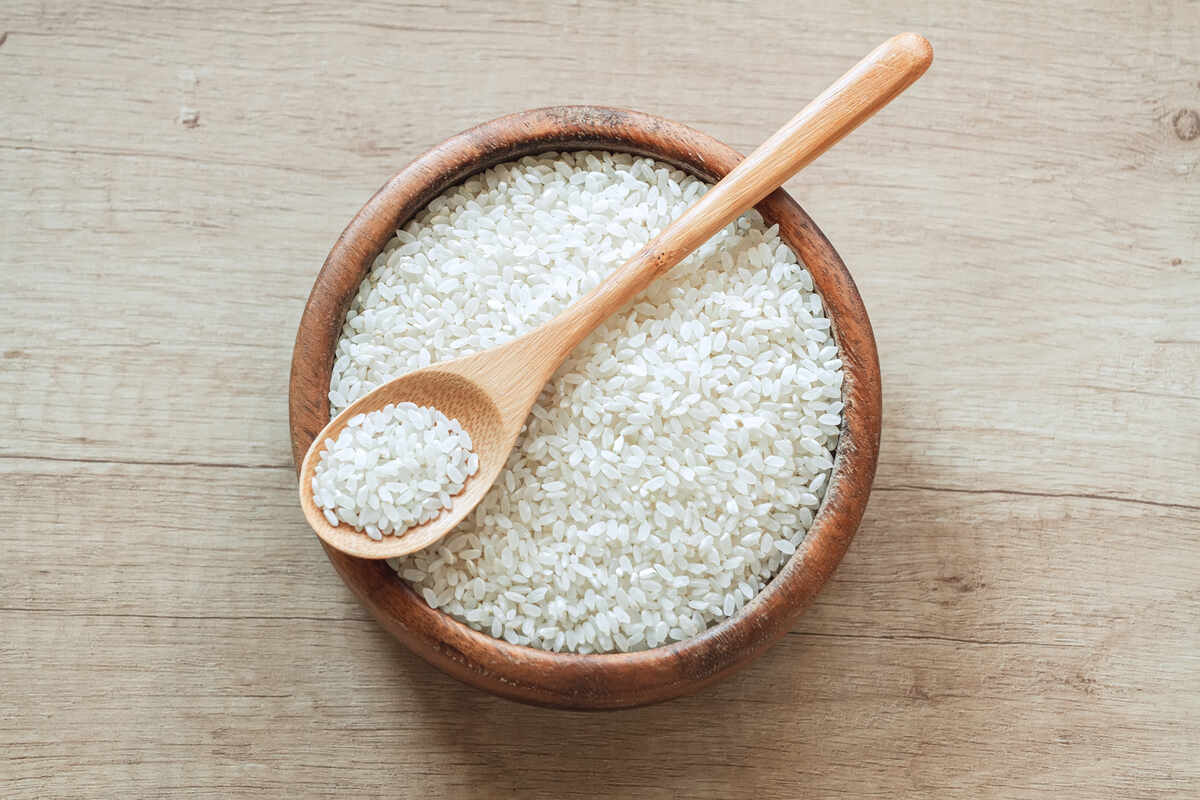 Riz blanc sur une table en bois avec une cuillère.