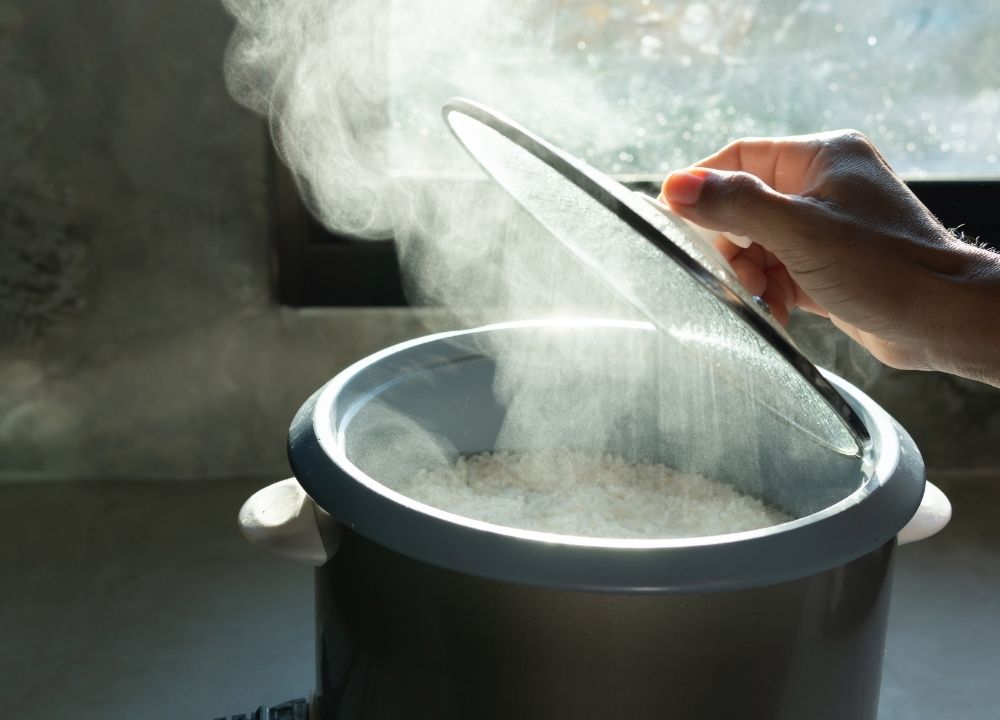 ارتفاع البخار بعد رفع الغطاء عن ايناء يظهر الأرز في الوسط