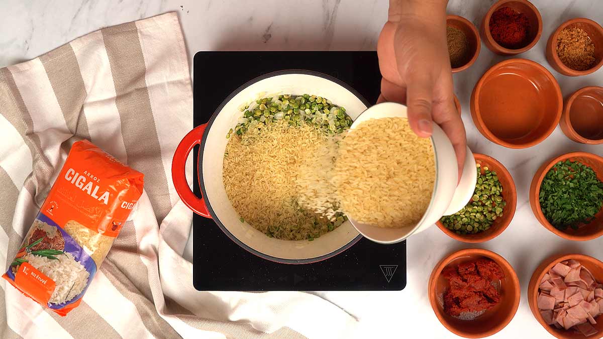 Cuisson des pois cassés et du riz ajout du riz étuvé Aroz Cigala aux pois cassés, oignons et ail