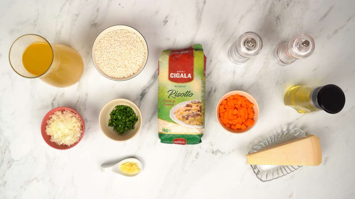 Préparation des ingrédients Tous les ingrédients nécessaires à la recette de risotto, y compris le riz, les légumes et le fromage, sont disposés sur la table.