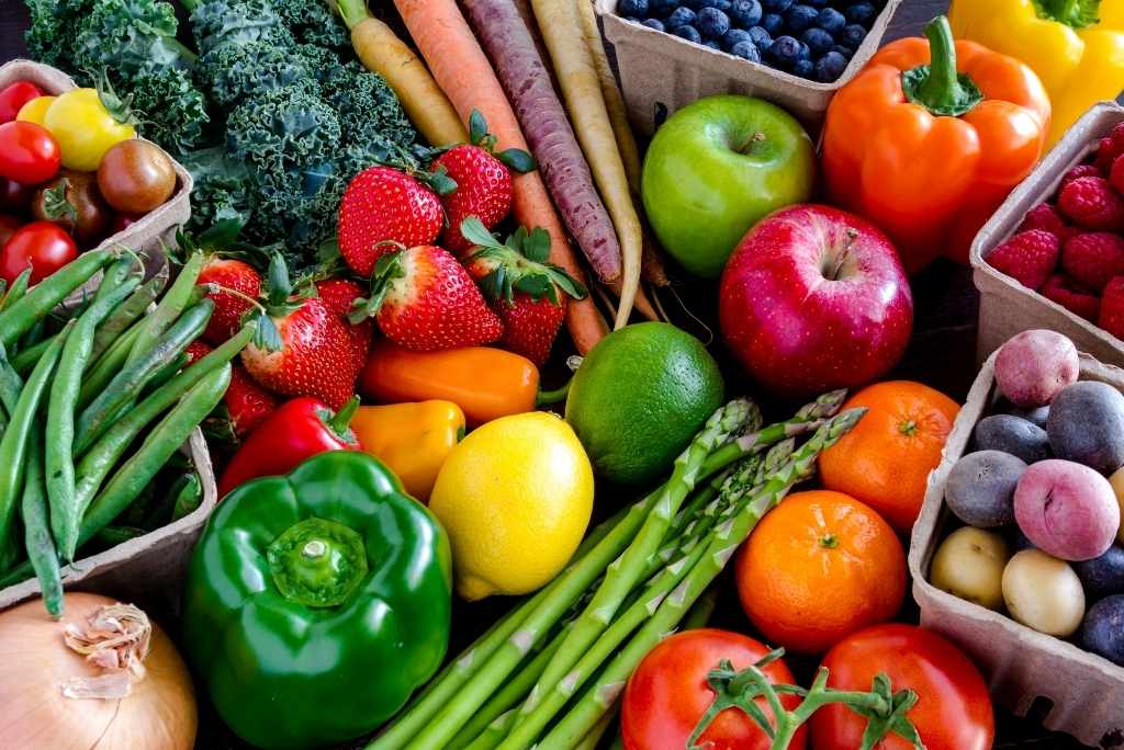 Priorité aux fruits, légumes et céréales complètes Gros plan sur un assortiment très coloré et dense de fruits et légumes frais.