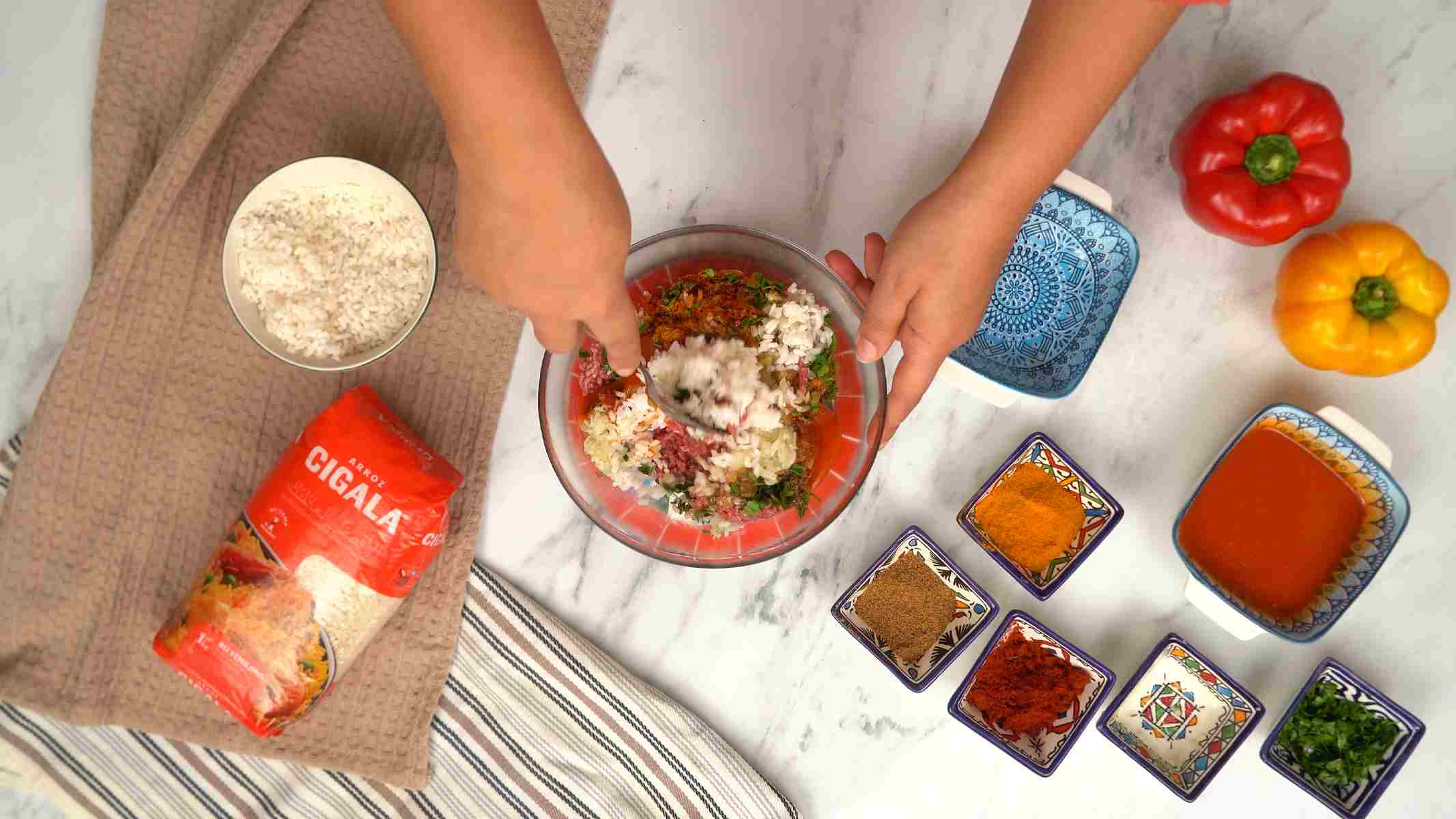 في وعاء كبير، يتم خلط الأرز المطهو مع اللحم المفروم، والأعشاب الطازجة، ومزيج التوابل.