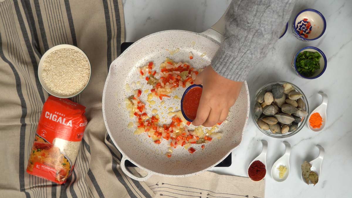 نبدأ بتشويح البصل والفلفل قبل إضافة صلصة الطماطم في المقلاة.