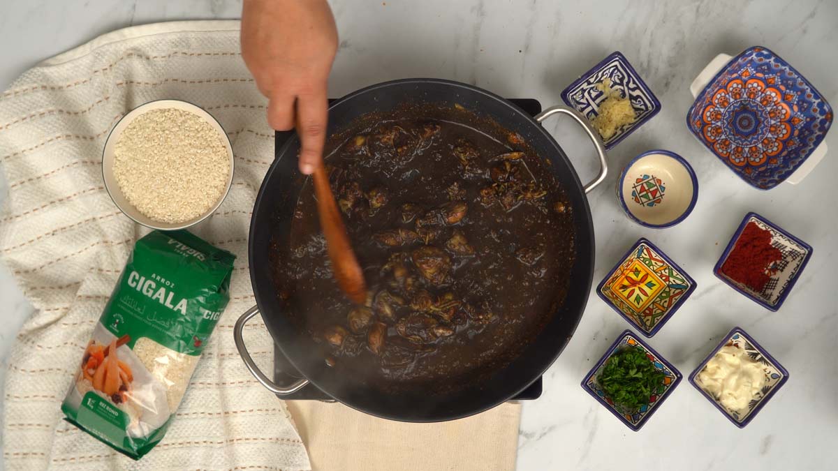 On fait revenir les calamars dans une poêle avec de l'encre de seiche pour obtenir cette base sombre et parfumée.