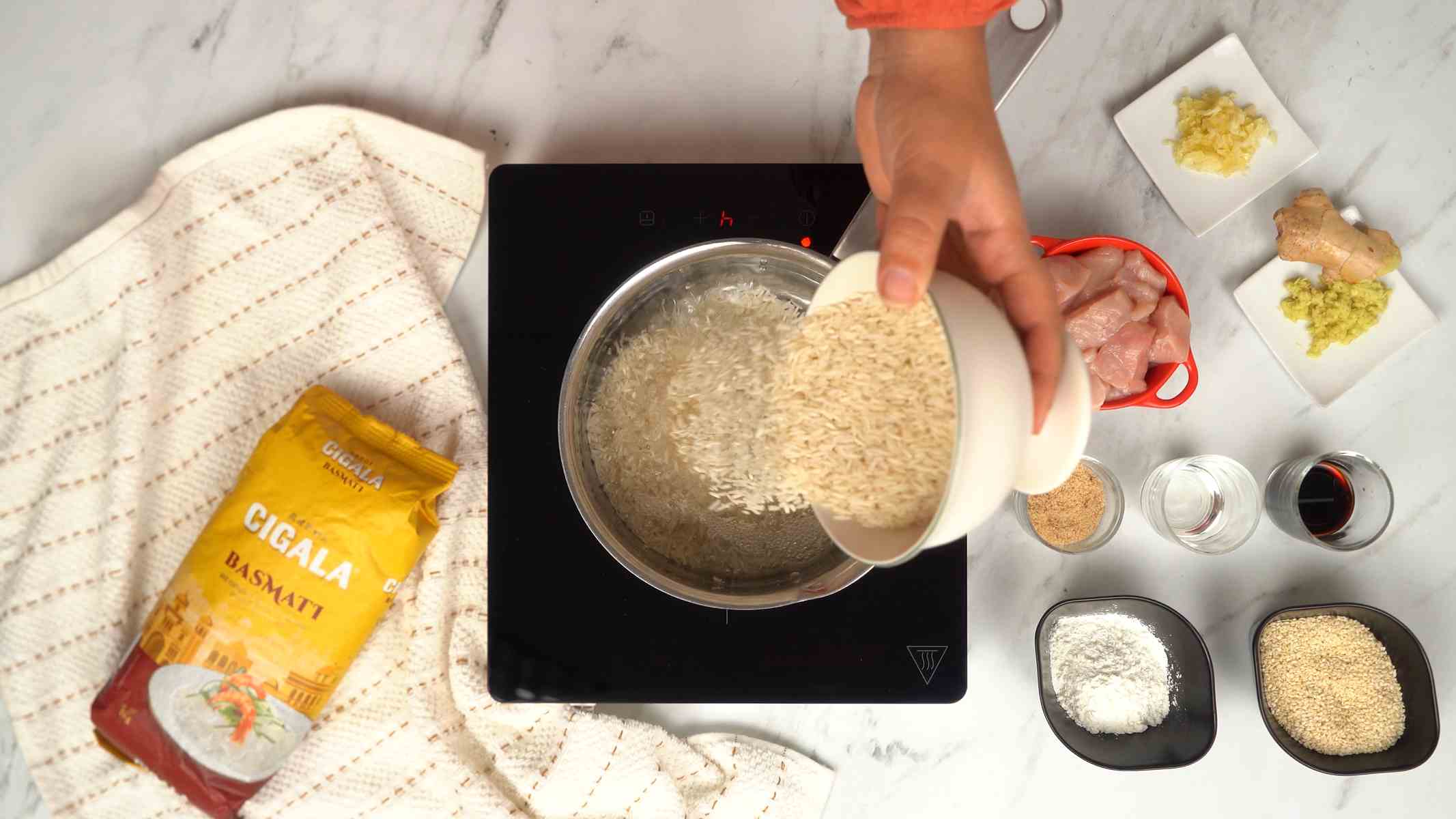 يُسكب أرز البسمتي في قدر من الماء المغلي لطهيه.