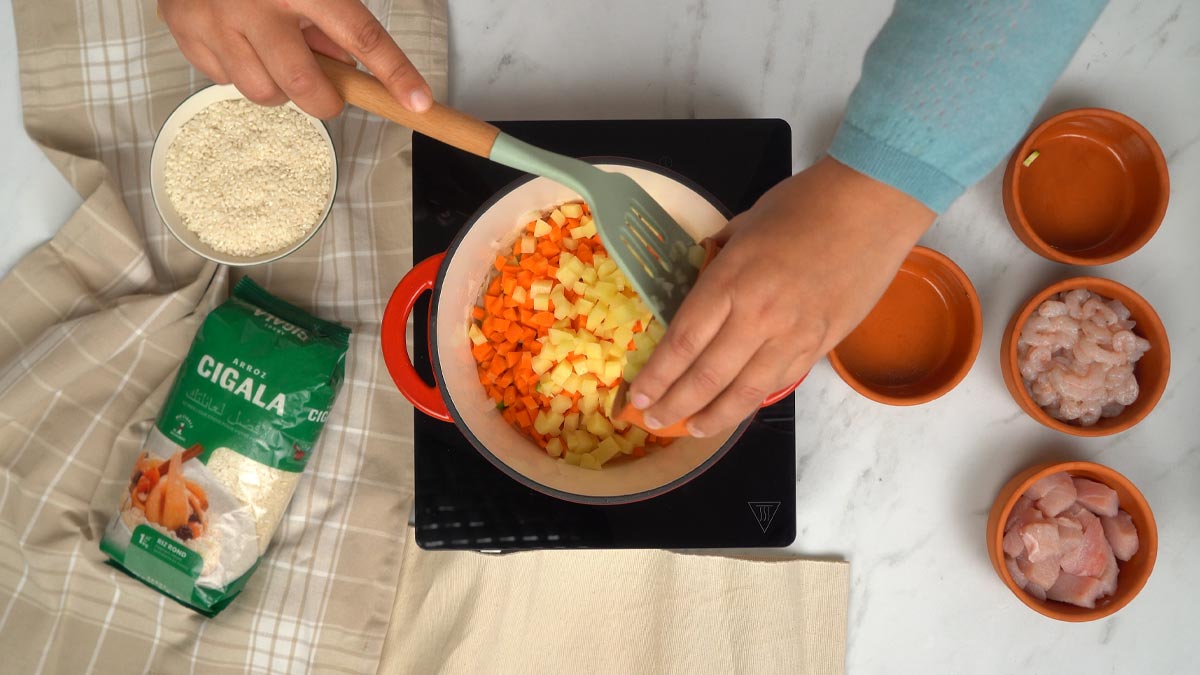 Ajout des légumes On fait revenir les carottes et les pommes de terre dans une marmite pour commencer la cuisson des légumes.