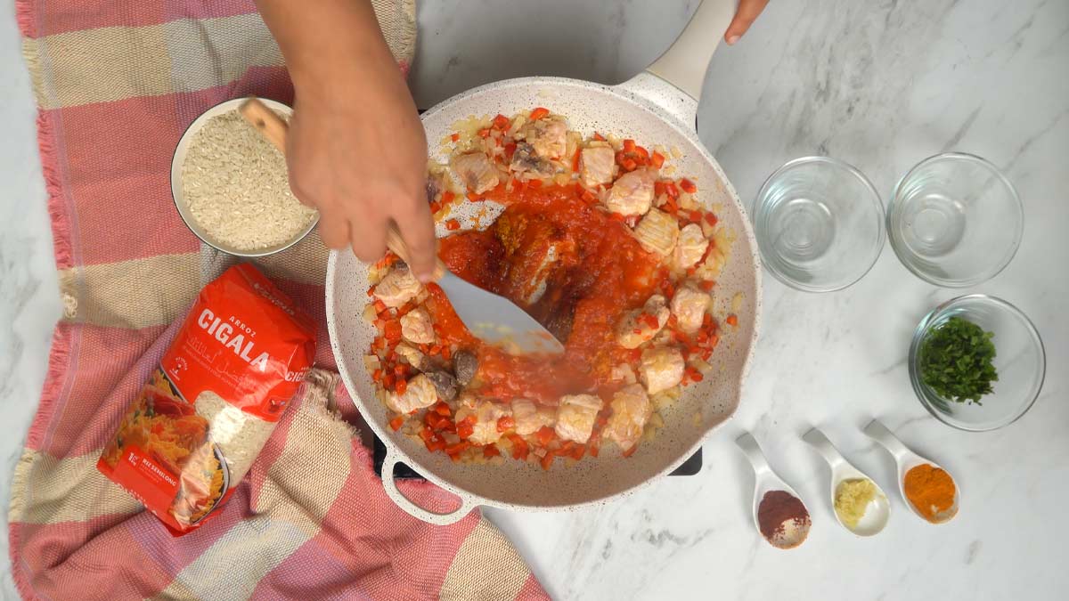 Ajout de la sauce et des épices On ajoute la sauce tomate à la préparation pour créer une base onctueuse et colorée.