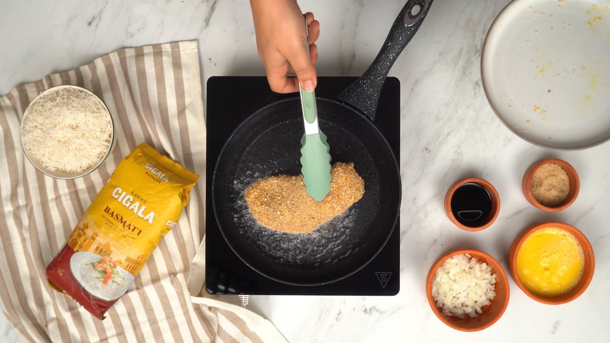 يُحمَّر الدجاج المغلّف بالبقسماط في مقلاة مع القليل من الزيت حتى يصبح مقرمشًا.