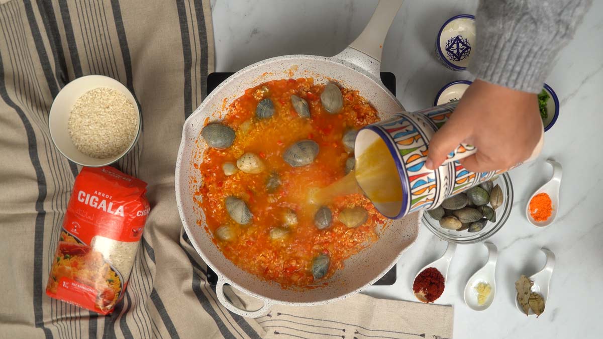 نضيف المحار ونسكب المرق الساخن لبدء الطهي.