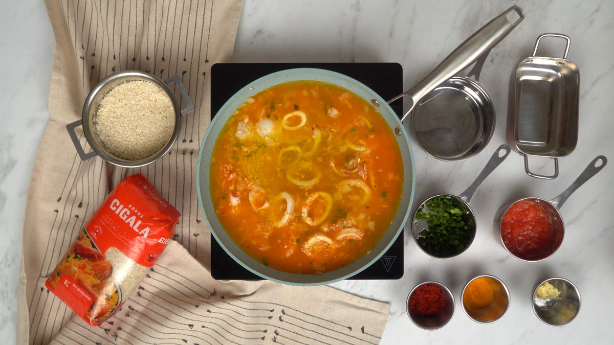 نُضيف المرق الساخن إلى التحضير ونتركه يطهى برفق حتى امتصاص السائل بالكامل.