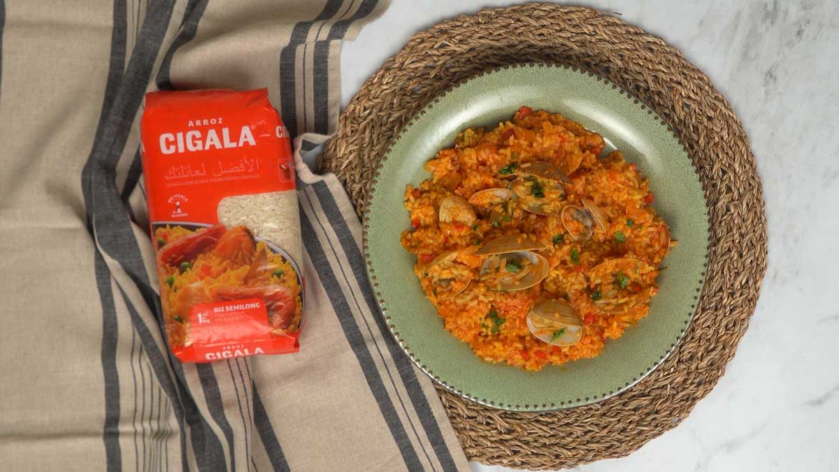 يُقدَّم أرز المحار ساخناً بلون برتقالي جميل ومزيّناً بالبقدونس الطازج.