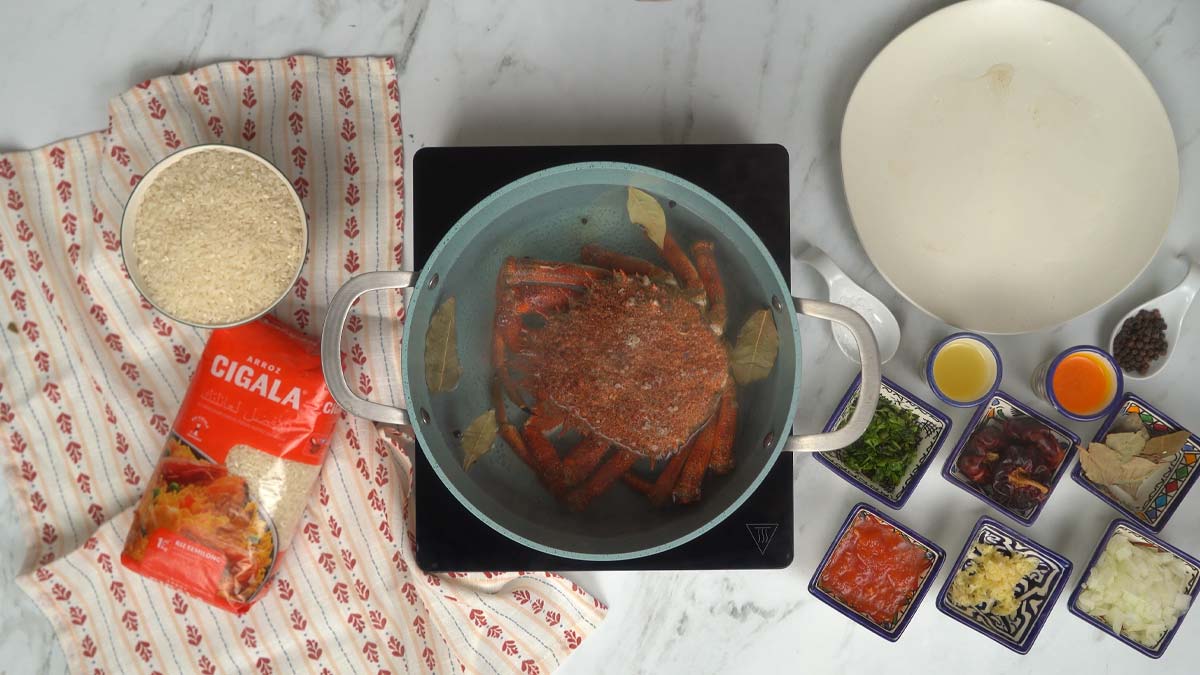 نبدأ بطهي السلطعون في قدر كبير من الماء المغلي مع أوراق الغار لتعطير اللحم.