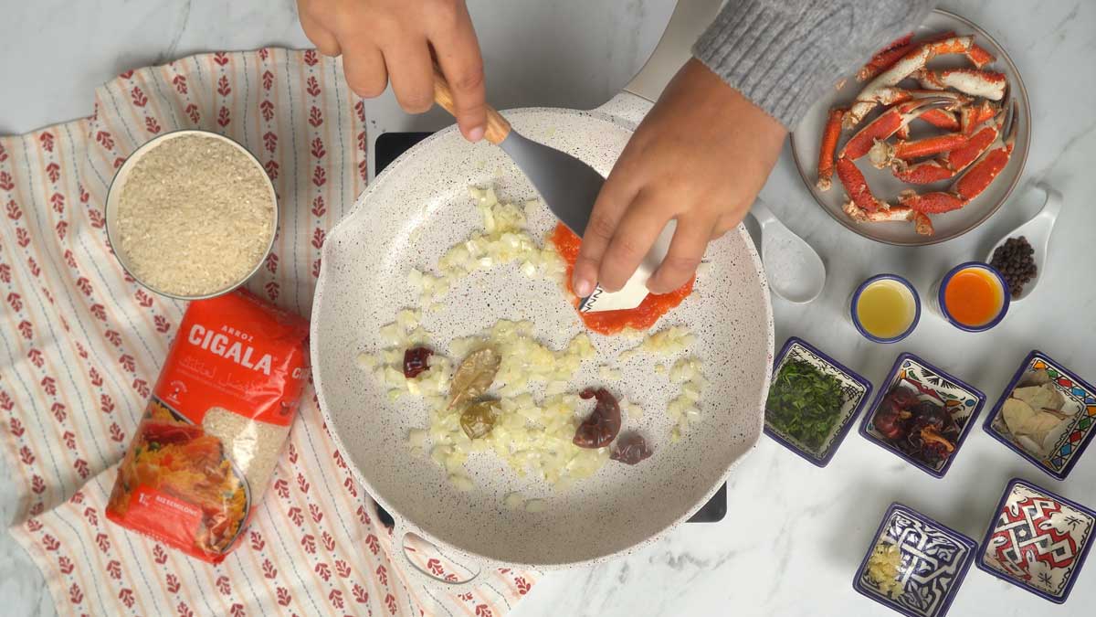 في مقلاة، نُشوّح البصل المفروم مع الثوم وصلصة الطماطم لتكوين قاعدة غنية بالنكهة.